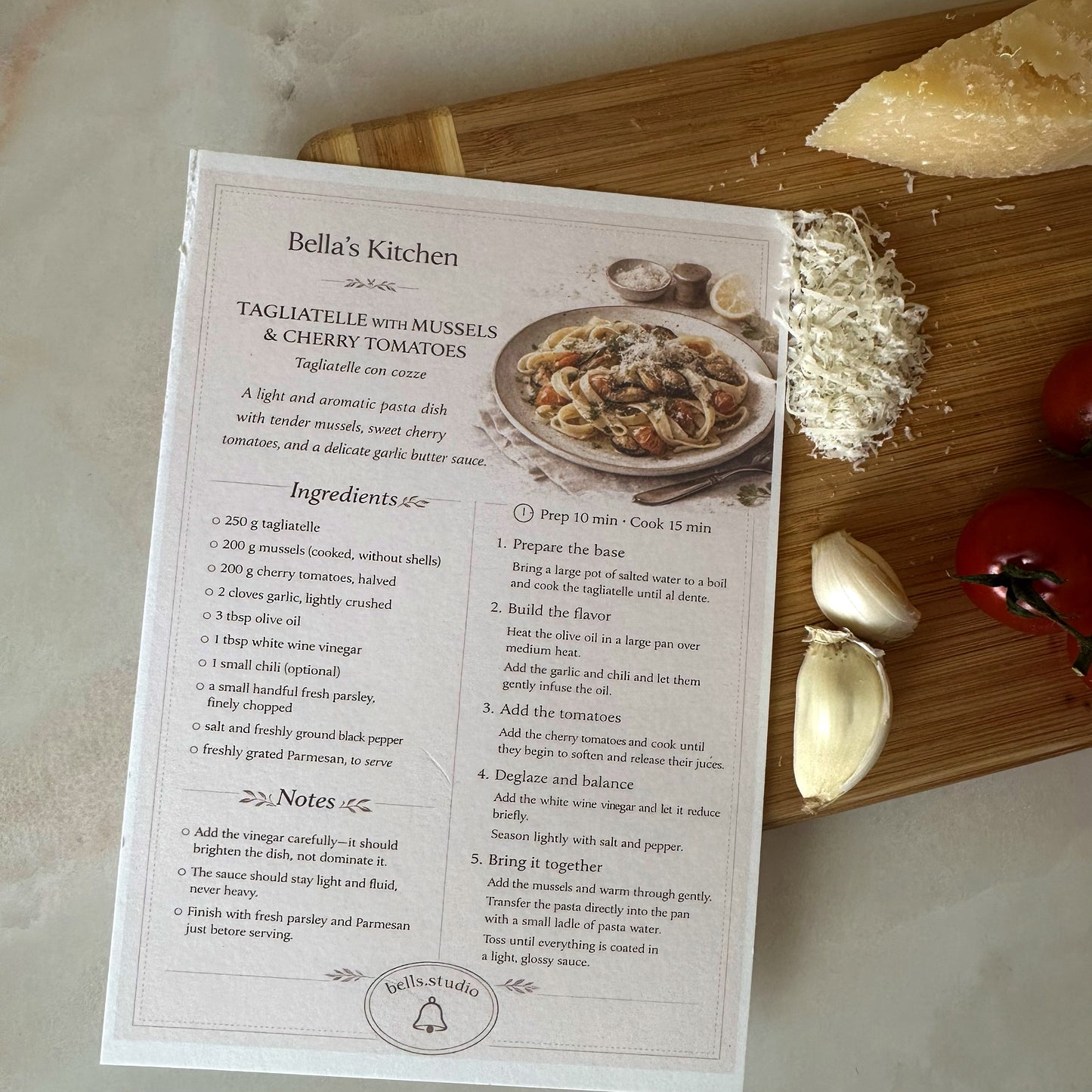 Recipe card for 'Tagliatelle with Mussels & Cherry Tomatoes' from Bella's Kitchen on a wooden cutting board with ingredients.