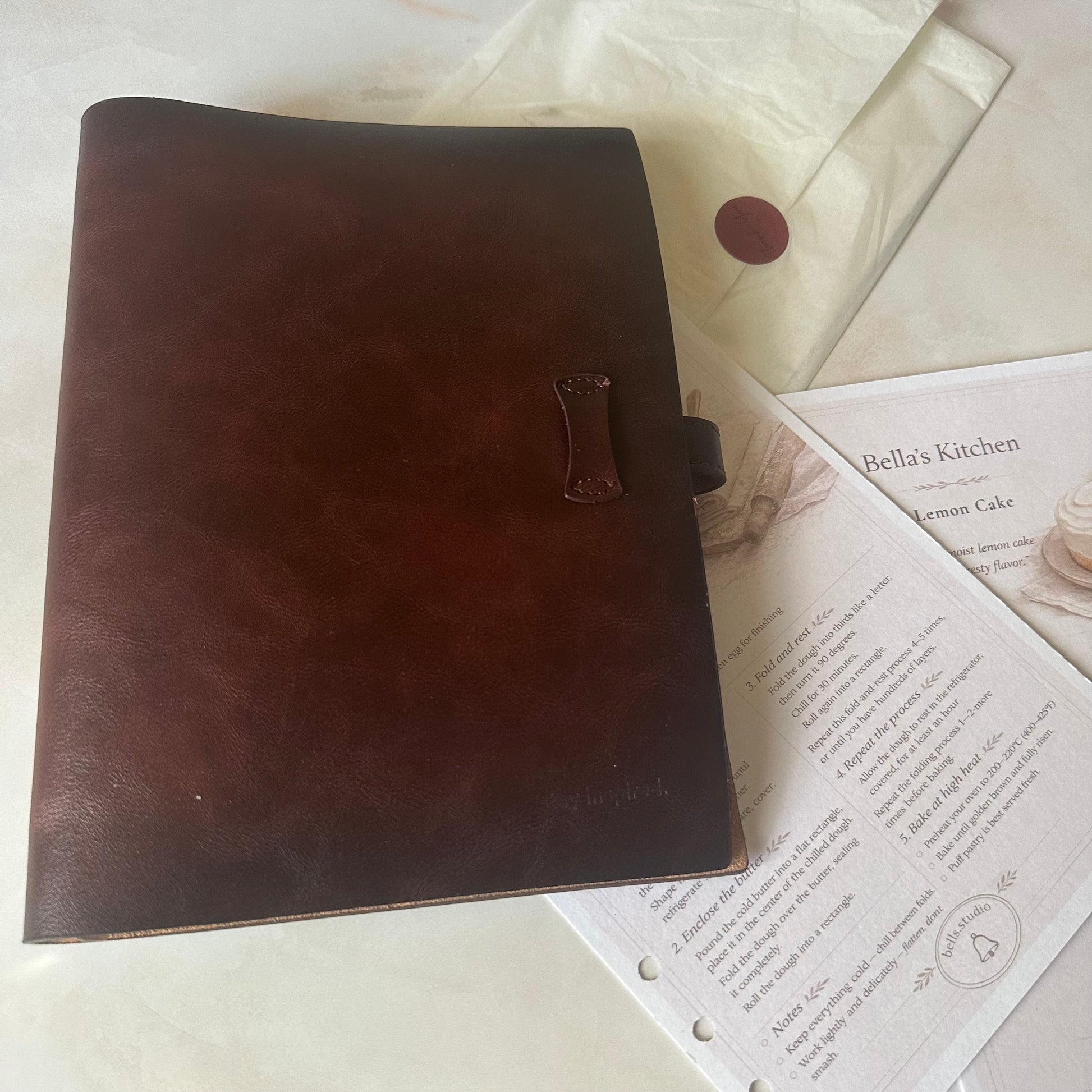Brown leather notebook on top of a recipe book with visible text.